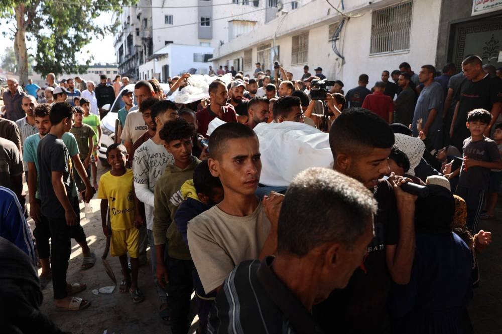 Mourners carry shrouded bodies of Palestinian, killed in an Israeli strike, during the funeral procession at Al-Shifa hospital in Gaza City, in the central Gaza Strip on, on Wednesday. AFP