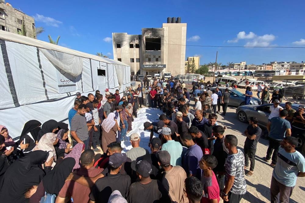 People mourn over the bodies of Palestinians, killed in an Israeli strike, during their funeral outside the Nasser Hospital in the southern Gaza Strip city on, on Wednesday. AFP