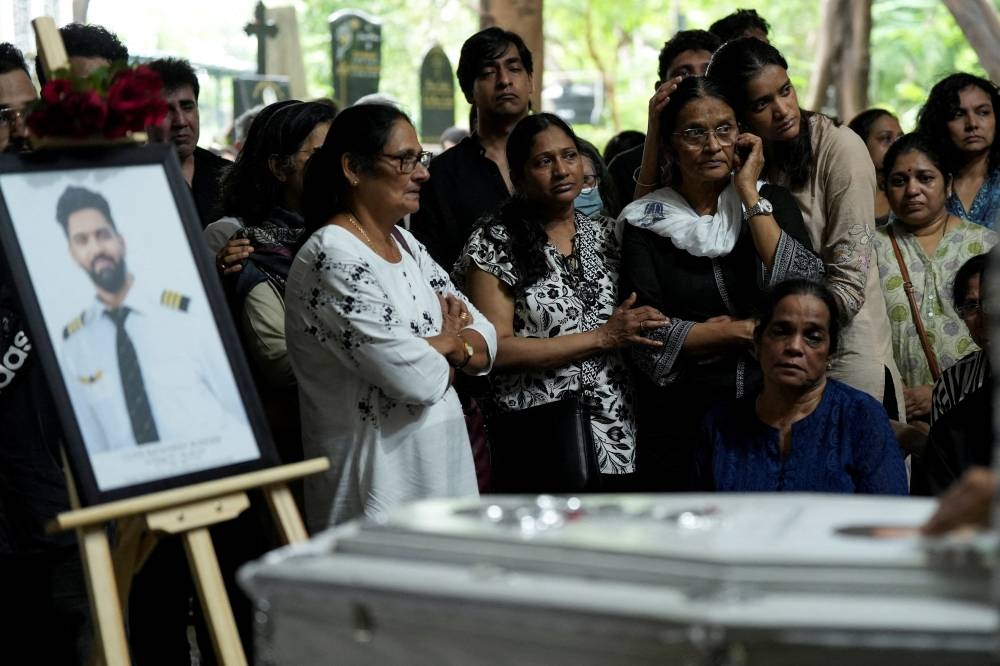 Friends and family members mourn near the coffin of Co-Pilot Clive Kunder, who died after an AIR India Boeing 787-8 Dreamliner plane crashed during take-off from an airport in Ahmedabad, in Mumbai, India June 19. REUTERS