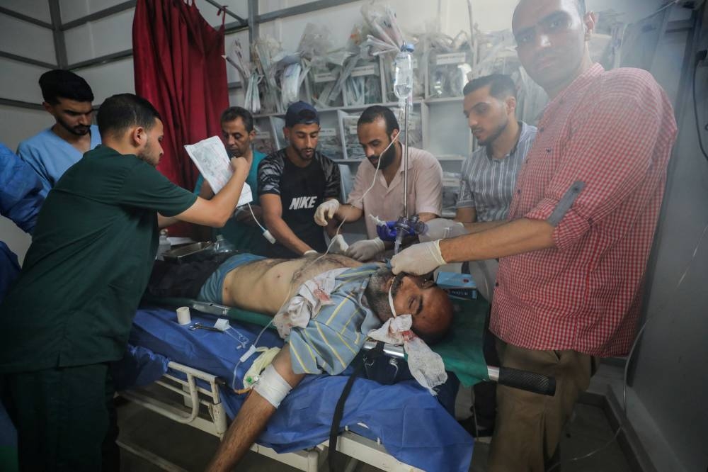 A Palestinian casualty receives treatment at Al-Awda Hospital, in the aftermath of an Israeli strike that killed people, who gathered to collect water from a distribution point, in Nuseirat in the central Gaza Strip, on Sunday. REUTERS