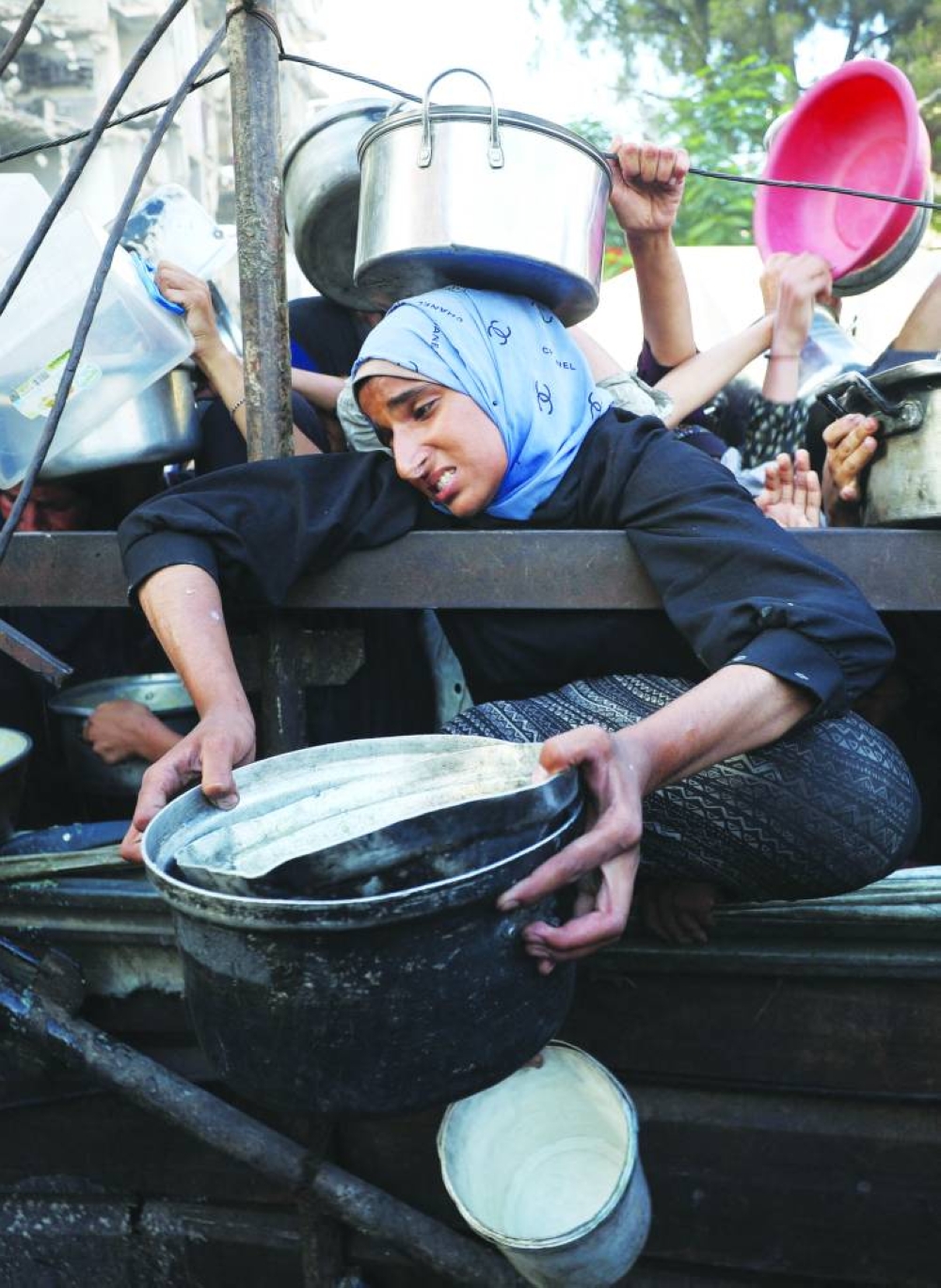A Palestinian woman reacts as she asks for food from a charity kitchen, amid a hunger crisis, in Gaza City, Monday.