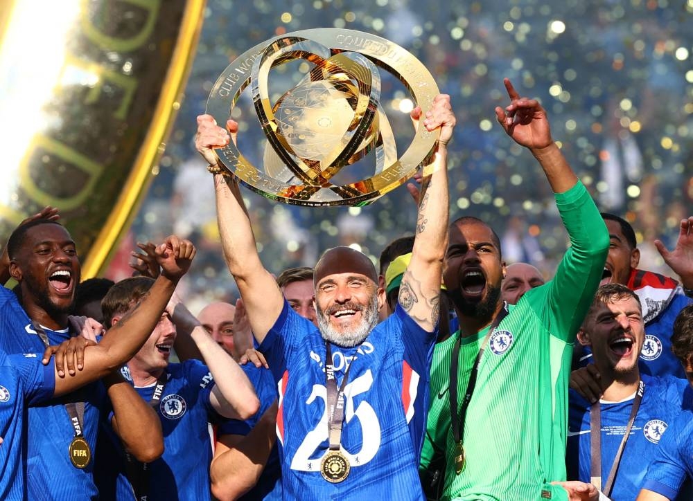 Soccer Football - FIFA Club World Cup - Final - Chelsea v Paris St Germain - MetLife Stadium, East Rutherford, New Jersey, U.S. - July 13, 2025 Chelsea manager Enzo Maresca lifts the trophy as he celebrates with Chelsea players after winning the FIFA Club World Cup REUTERS/Kai Pfaffenbach