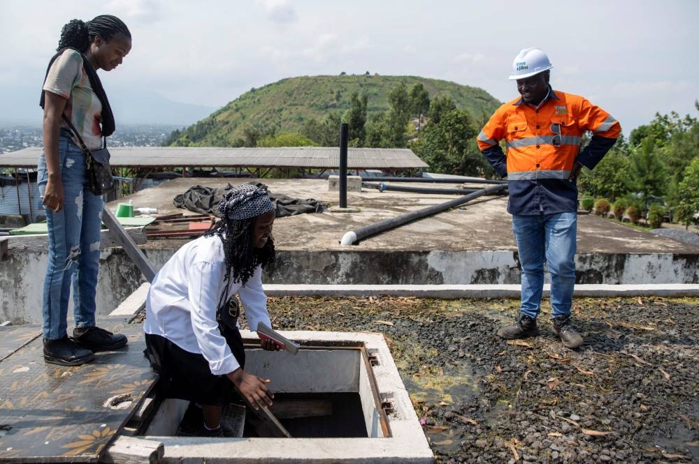 Yves Ntaboba, Technical Director of Yme Jibu, explains water connection plan to students at the non-operational reservoir, where construction has stalled due to USAID funding cuts to the NGO Mercy Corps, in Goma, North Kivu province, Democratic Republic of Congo.