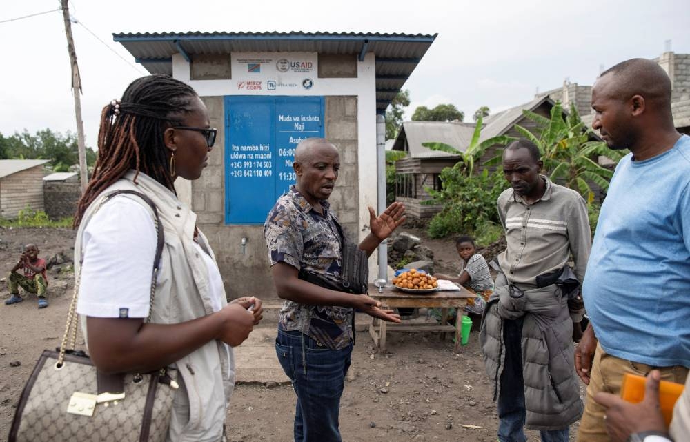 Etienne Mutaulwa, in charge of the standpipes, talks with Mercy Corps officials as incomplete water connections caused by USAID funding cuts to the NGO Mercy Corps have led to ongoing water shortages, in Goma, North Kivu province, Democratic Republic of Congo, June 16, 2025. REUTERS/Arlette Bashizi