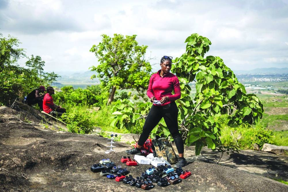 A hiker sells sunglasses on the top of a hill during a group hike on the outskirts of Abuja, Nigeria.