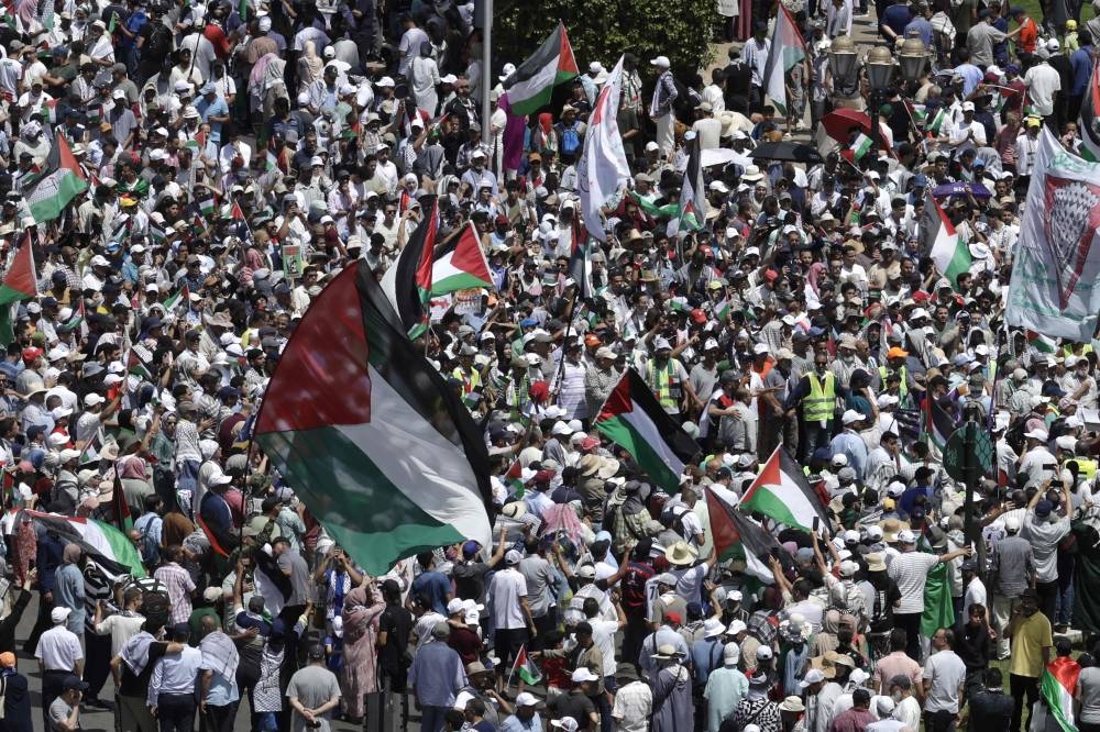 Moroccans wave Palestinian flags during a march to express their solidarity with the Palestinians in the Gaza Strip, in Rabat