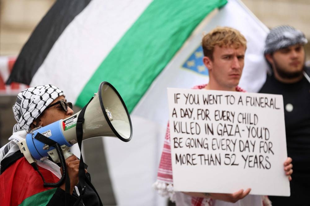 Pro-Palestinian supporters chant slogans and hold placards as they rally in front of the Foreign & Commonwealth Office, in central London, yesterday.