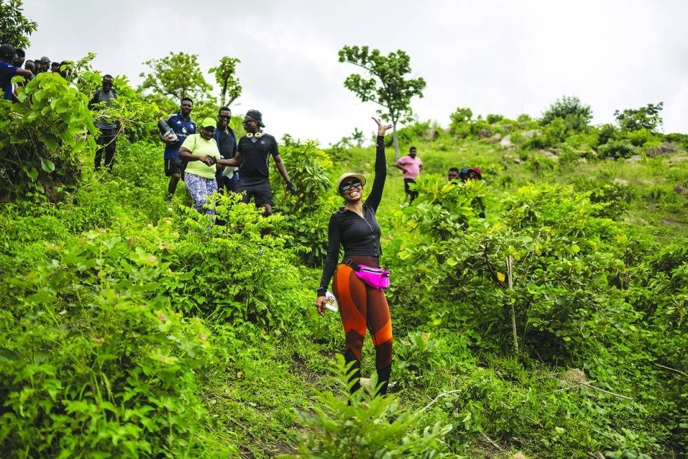 A hiker poses for a photograph as she descends a hill during a group hike on the outskirts of Abuja, Nigeria, on June 28, 2025. With no trail post in sight, the unmarked dirt lot outside the Nigerian capital seemed an unlikely place to hike but fans of the great outdoors in Abuja have long taken matters into their own hands.
"Most of the trails in Abuja are not properly mapped," said Adebayo Babatunde, founder of Naija Adventurers which is a shame, he added, "because nature is a beautiful place where we all need to connect back to".
The group and a handful of others have cropped up to provide a service the government has long ignored, organising hikes in a city where, despite being ringed by verdant hills, public trails are virtually nonexistent. (Photo by OLYMPIA DE MAISMONT / AFP)