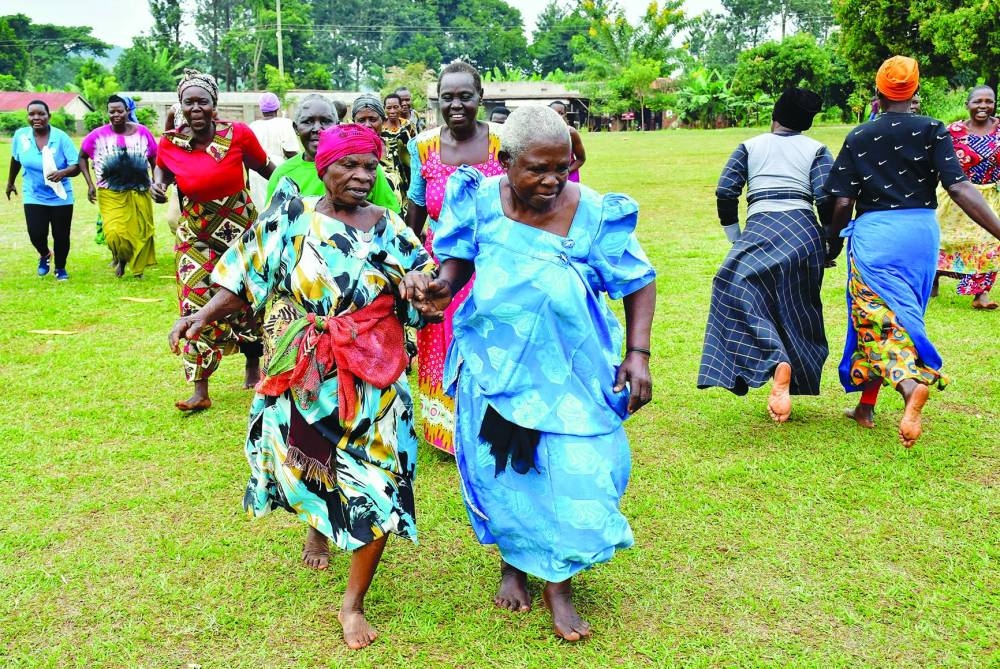 Elderly women run in pairs as they take part in a community-led fitness drills session that combines yoga, aerobics, and cricket drills to combat non-communicable diseases (NCDs) on a playing field in Kivubuka village, in Jinja District, Eastern Uganda, July 12, 2025. REUTERS/Abubaker Lubowa