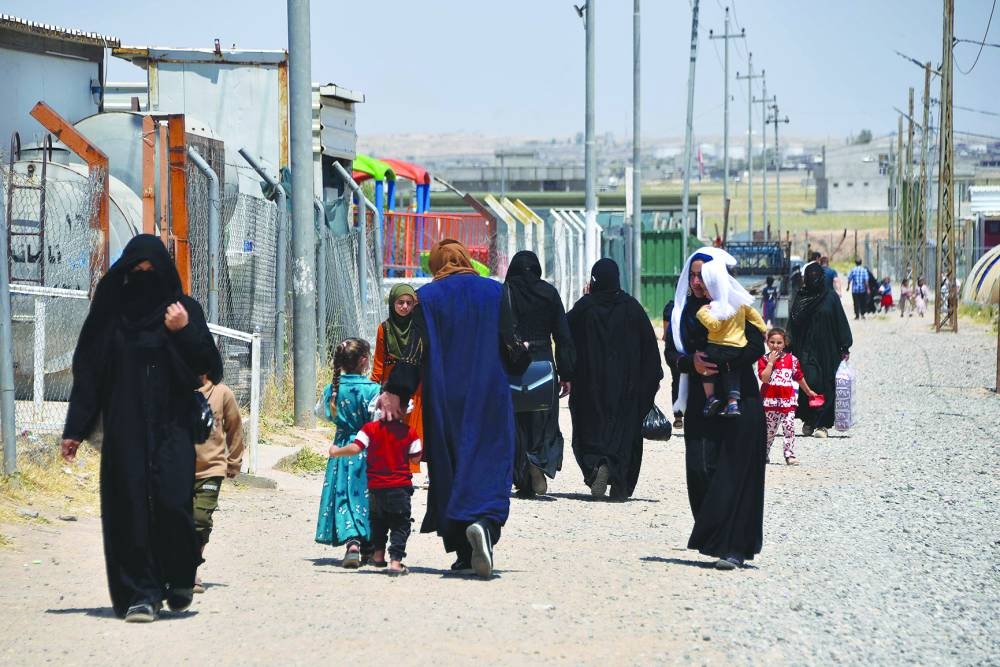 File photo shows women and children walk at the Al-Amal Camp (formerly Al-Jadaa), south of Mosul in northern Iraq, which houses Iraqi families who have been repatriated from Syria's Al-Hol camp.