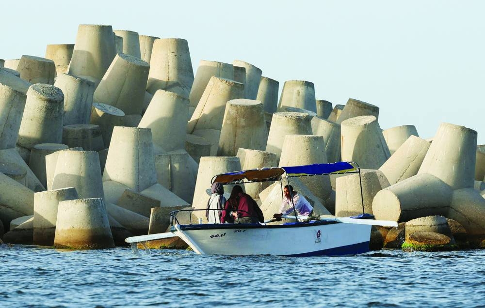 People ride in a boat past the newly built concrete barrier in the Mediterranean city of Alexandria, Egypt, April 20, 2025. REUTERS/Mohamed Abd El Ghany