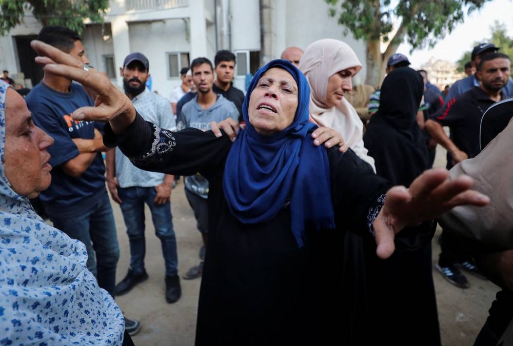 A woman mourns at a funeral of Palestinians killed by Israeli fire while trying to receive aid at Al-Shifa Hospital in Gaza City, yesterday.
