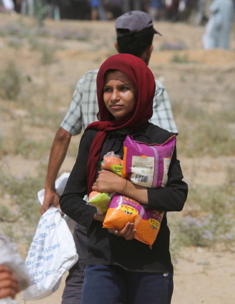 A Palestinian girl holds food items collected from aid packages dropped from an airplane, amid a hunger crisis, in Zawayda, in the central Gaza Strip, Monday.