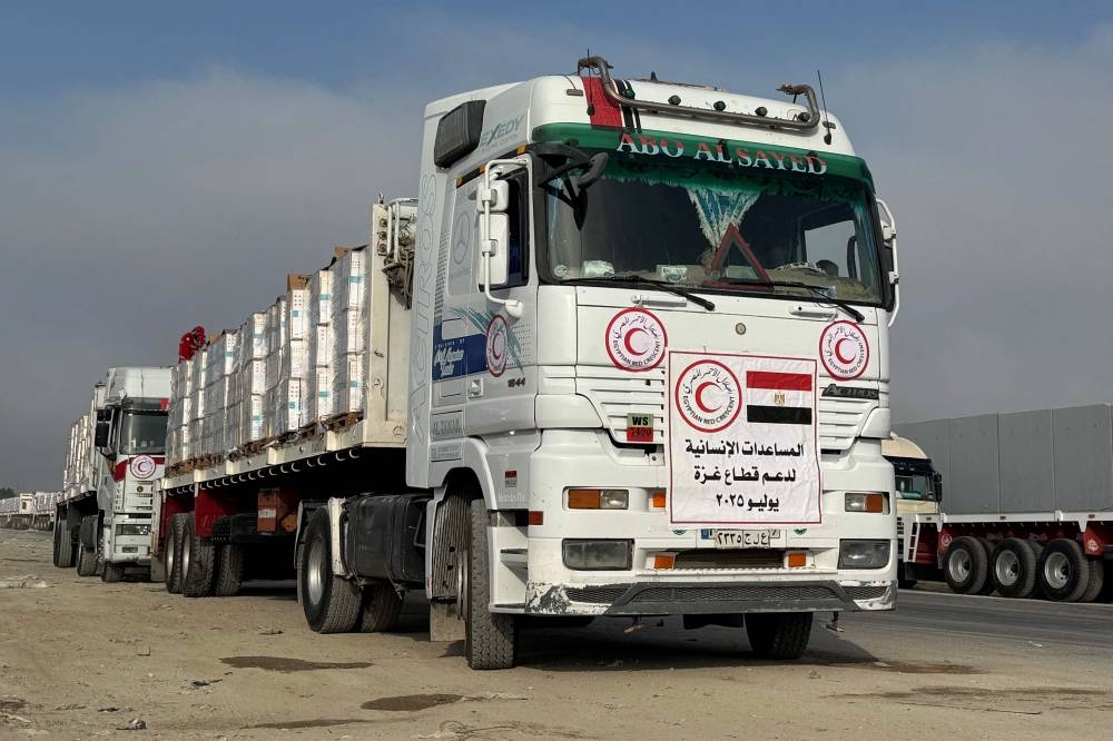 Trucks carrying humanitarian aid wait to be allowed to cross from the Egyptian side of the Rafah border crossing with the Gaza Strip, Monday.
