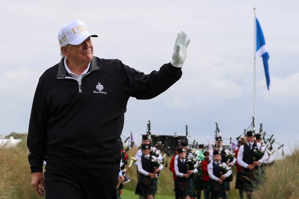 Trump waves on the day of the grand opening of Trump International Golf Links Aberdeen in Balmedie, Aberdeen, Scotland. – Reuters