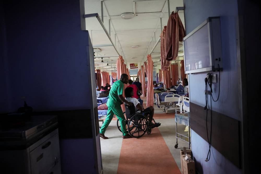 An injured patient is wheeled out of the out-patient ward of the National Orthopaedic Hospital, as Nigerian nurses begin a strike over poor support from the government, in Lagos, Nigeria, July 30, 2025. REUTERS/Sodiq Adelakun