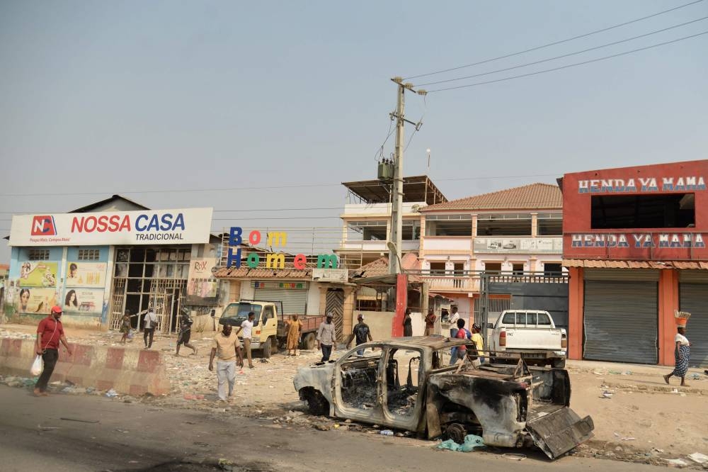 Residents walk past a looted supermarket in the Kalemba 2 district of Luanda during a general strike in the taxi sector, to protest against the rising prices of fuel.