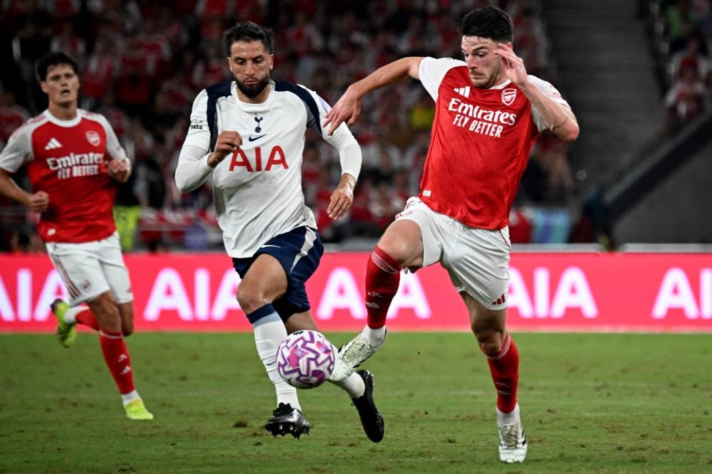 Arsenal痴 Declan Rice (R) and Tottenham Hotspur&#039;s Rodrigo Bentancur fight for the ball during their friendly exhibition football match at the Kai Tak Stadium in Hong Kong on July 31, 2025. (Photo by Peter PARKS / AFP)