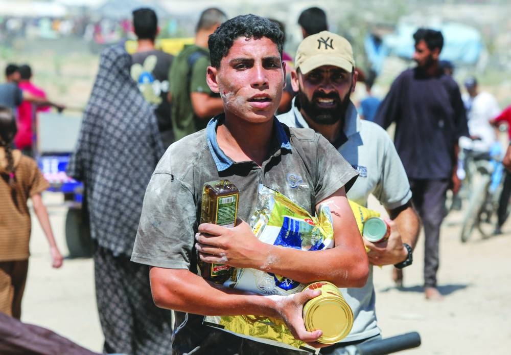 Palestinians collect aid parcels that were airdropped, in the central Gaza Strip, Thursday.