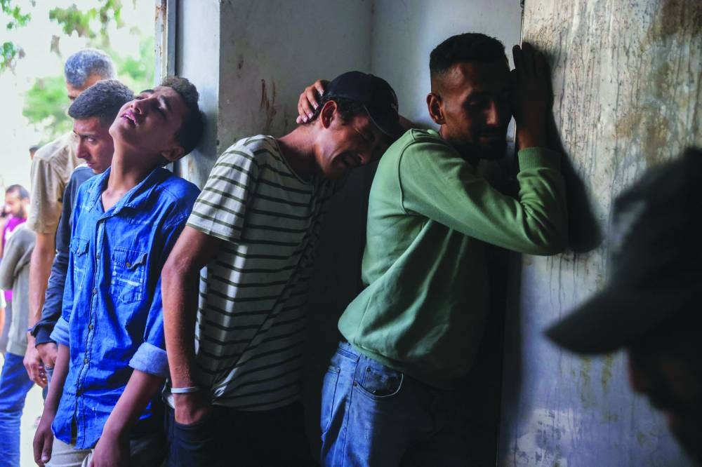 Palestinians mourn outside the morgue where bodies of people killed while waiting for aid were brought, at the Al-Shifa hospital in Gaza City Thursday.