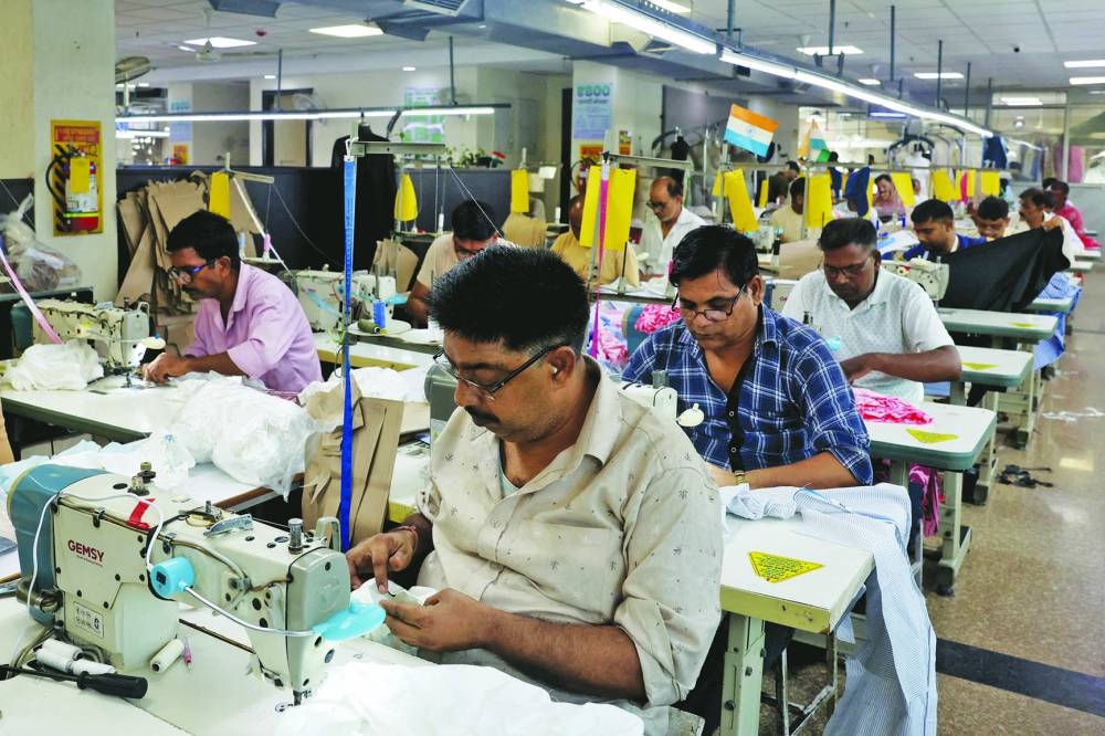 
Garment workers stitch shirts at a textile factory in Noida, India, yesterday. 