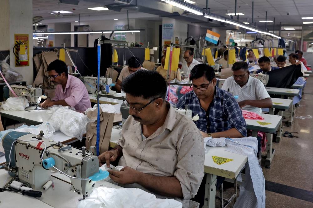 Garment workers stitch shirts at a textile factory in Noida, India, yesterday.
