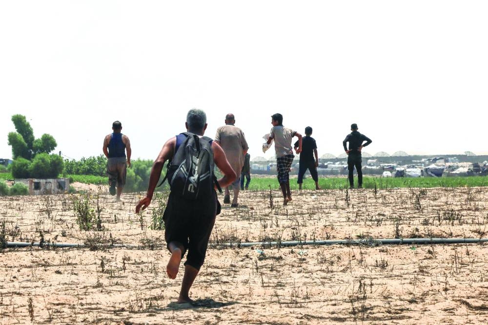 People run toward an area where food parcels were airdropped in Rafah in the southern Gaza Strip yesterday.