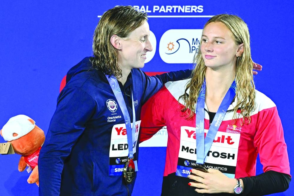 (L-R) Gold medallist US' swimmer Katie Ledecky and silver medallist Canada's swimmer Summer McIntosh pose on the podium of the women's 800m freestyle swimming event during the 2025 World Aquatics Championships in Singapore on August 2, 2025. (Photo by Oli SCARFF / AFP)