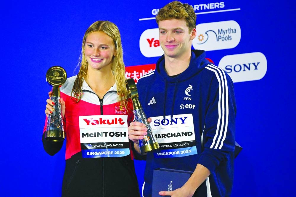 Canada’s Summer Mcintosh and France’s Leon Marchand pose with their best women’s and men’s championship swimmers awards at the end of the swimming event during the 2025 World Aquatics Championships in Singapore Sunday. (AFP)
