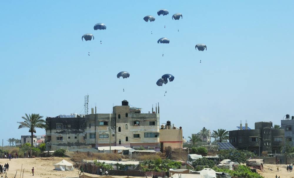 
Aid packages dropped from an airplane descend over Gaza, in Zawayda, in the central Gaza Strip yesterday. 