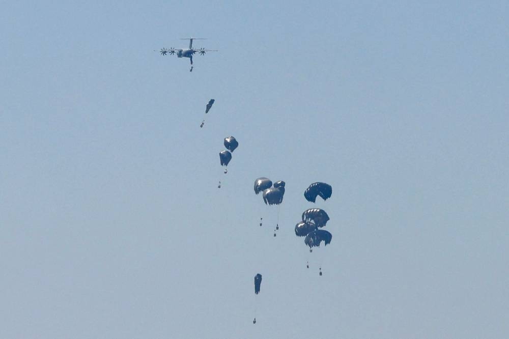 A German Air Force (Luftwaffe) A400M Atlas military transport aircraft releases aid pallets while flying over Nuseirat in the central Gaza Strip during an airdrop mission above the Israel-besieged Palestinian territory on Monday. AFP