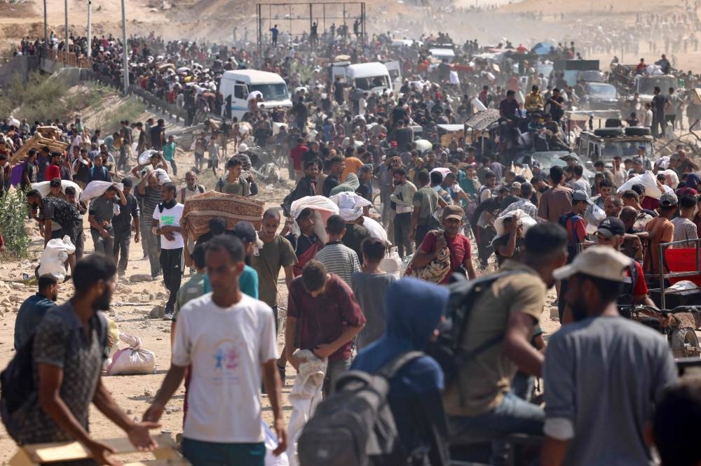 Displaced Palestinians gather to receive aid run by the US and Israeli-backed Gaza Humanitarian Foundation (GHF) at the so-called "Netzarim corridor" in the central Gaza Strip on Monday. AFP
