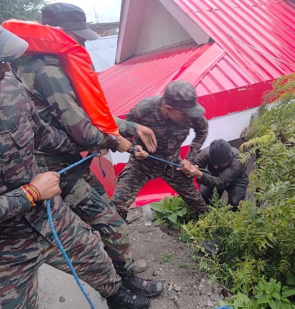 Rescuers assist a man, amid flash floods, in a location given as Dharali, Uttarakhand, India, in this handout image released on Tuesday. Indian Army Central Command/Handout via REUTERS