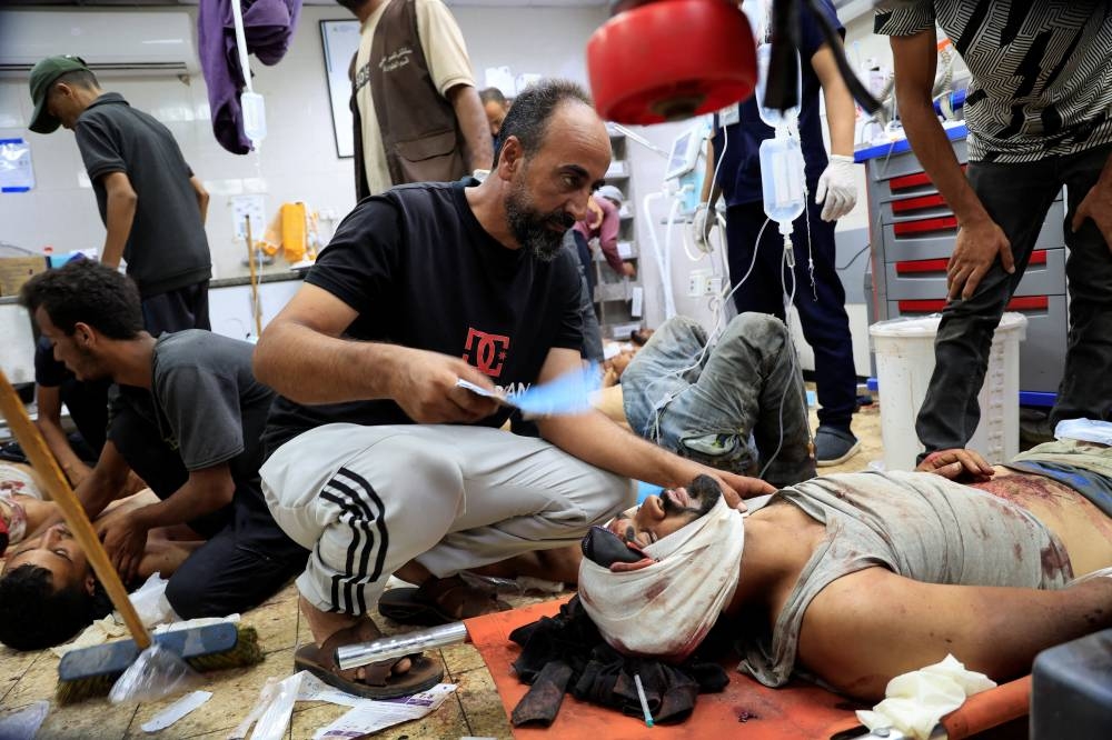 Palestinian casualties of Israeli fire, who were seeking aid, are assisted at Nasser Hospital in Khan Younis, southern Gaza Strip, on Tuesday. REUTERS