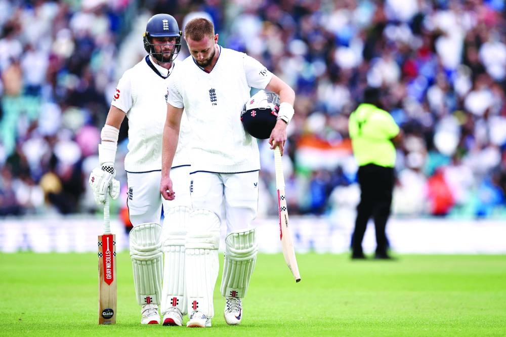 England’s Gus Atkinson and England’s Chris Woakes (left) walk back to the pavilion after losing the final Test against India at The Oval in London. (AFP)
