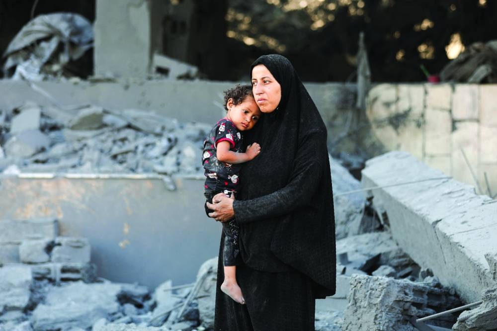 A Palestinian woman looks at the site surrounding an evacuated UNRWA clinic, following an overnight Israeli strike, in Gaza City Wednesday.