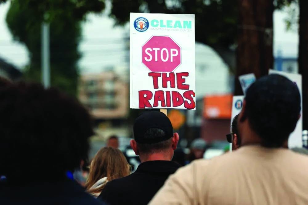 
A supporter holds a sign as relatives of people who were taken into custody by ICE at a car wash gather to call for their immediate release, in Culver City, California, US. (Reuters) 
