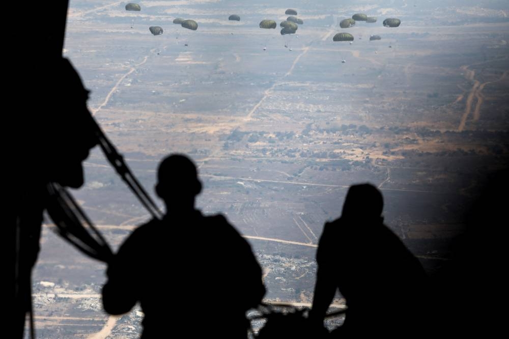 Jordanian military personnel airdrop aid parcels over Gaza, on Saturday. REUTERS