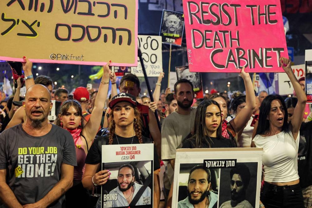 Einav Zangauker (R), mother of Israeli hostage Matan Zangauker, and Matan's girlfriend and former hostage Ilana Gritsevsky (2nd-L) gather with others to attend a demonstration organised by the families of the Israeli hostages taken captive in the Gaza Strip since the October 2023 calling for action to secure their release outside the Defence Ministry headquarters in Tel Aviv on Saturday. AFP