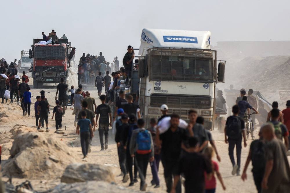 Palestinians seek aid supplies from trucks that entered Gaza through Israel, in Beit Lahia, in the northern Gaza Strip, Sunday.