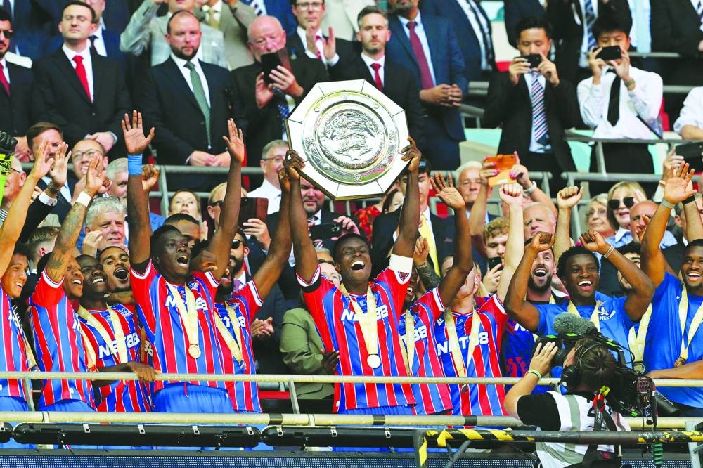 TOPSHOT - Crystal Palace's English defender Marc Guehi lifts the trophy after Palace win the English FA Community Shield football match between Crystal Palace and Liverpool at Wembley Stadium, in London on August 10, 2025. Palace won the penalty shoot-out 3-2 after the game finished 2-2 in 90 minutes. 