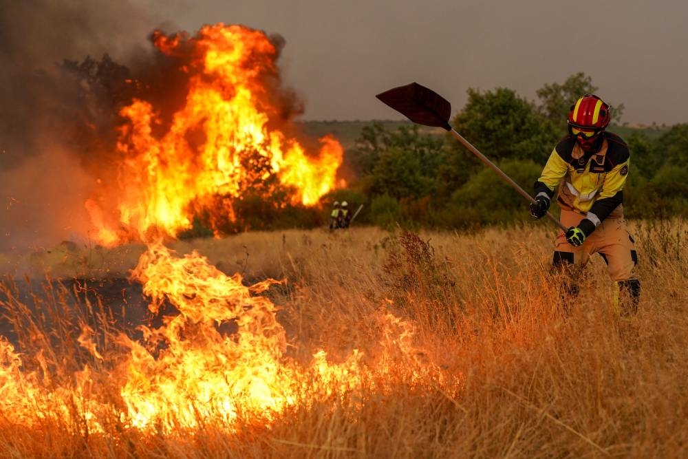 A firefighter works to extinguish a wildfire near Losacio, north of Zamora, on August 12, 2025. A man died from burns and thousands of people were forced to evacuate as wildfires swept through parts of Spain, fueled by strong winds and a searing heat wave that has gripped the country for 10 days. (AFP)