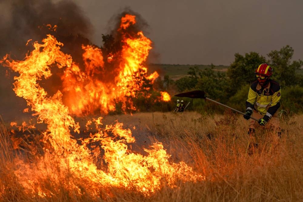 A firefighters works to extinguish a wildfire near Losacio, north of Zamora, on August 12, 2025. A man died from burns and thousands of people were forced to evacuate as wildfires swept through parts of Spain, fueled by strong winds and a searing heat wave that has gripped the country for 10 days. (AFP)