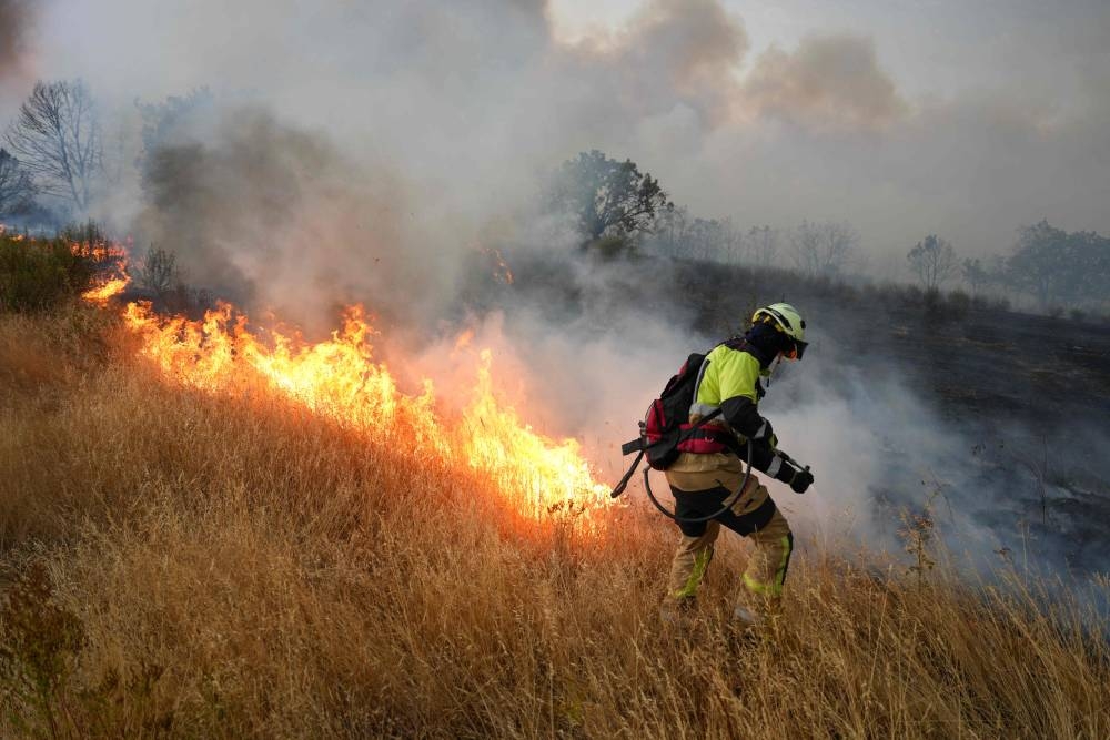 A firefighter works to extinguish a wildfire near Losacio, north of Zamora, on August 12, 2025. A man died from burns and thousands of people were forced to evacuate as wildfires swept through parts of Spain, fueled by strong winds and a searing heat wave that has gripped the country for 10 days. (AFP)