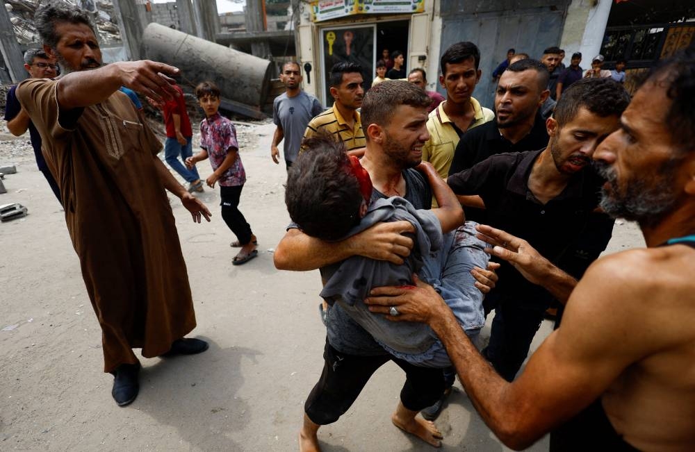 Palestinians carry a casualty following an Israeli airstrike, in Gaza City, on Tuesday. REUTERS
