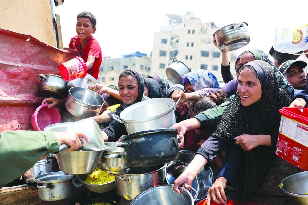 Palestinians gather to receive cooked meals from a food distribution centre in Gaza City, Wednesday.