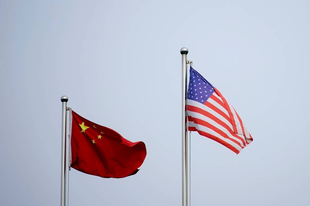 Chinese and US flags flutter outside a company building in Shanghai.