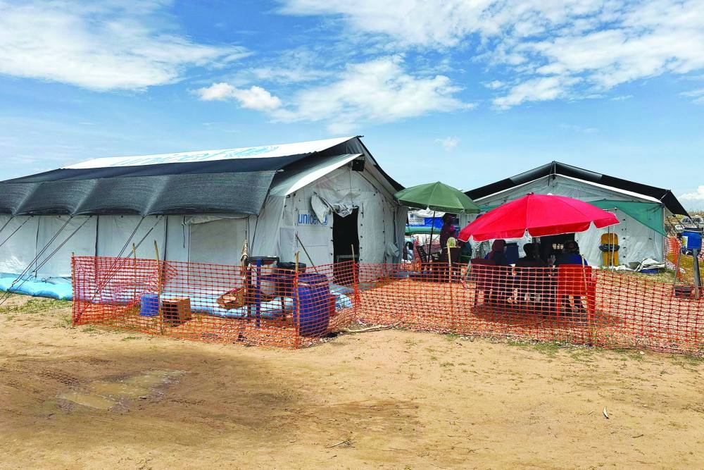 People sit outside the cholera isolation centre in at the refugee camps of western Sudan, in Tawila city in Darfur, on August 14, 2025. At least 40 people have died in Sudan's Darfur region in the country's worst cholera outbreak in years, Doctors Without Borders (MSF) said on August 14. (Photo by AFP)