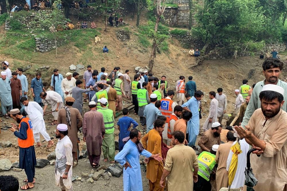Rescue workers and residents gather after cloudburst following the heavy rains and floodings, in Jibrari village in Salarzai Tehsil, Pakistan, on Friday. REUTERS