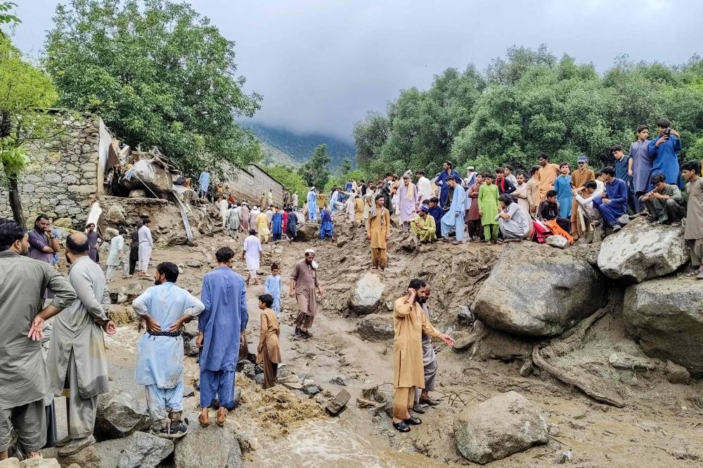 People gathered at the site of a flashflood in Salarzai Tehsil of Pakistan's Bajaur district, on Friday. AFP